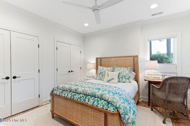 bedroom featuring two closets, visible vents, ornamental molding, and recessed lighting