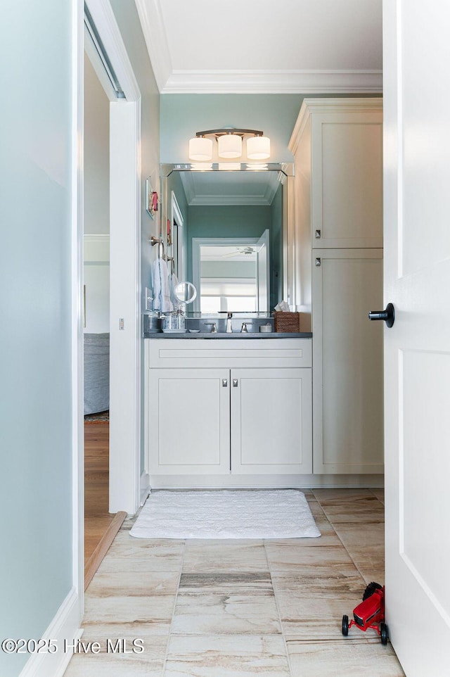 bathroom with vanity, ornamental molding, and wood finished floors