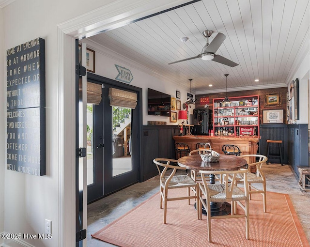 dining space with ornamental molding, a bar, wooden ceiling, and ceiling fan