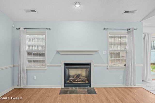 301 Derby Park Ave, New Bern, NC 28562 - unfurnished living room with visible vents, a fireplace with flush hearth, and wood finished floors