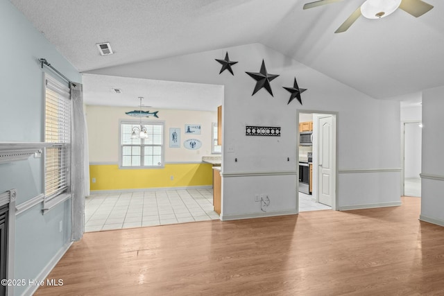 301 Derby Park Ave, New Bern, NC 28562 - interior space with visible vents, baseboards, light wood finished floors, ceiling fan with notable chandelier, and vaulted ceiling