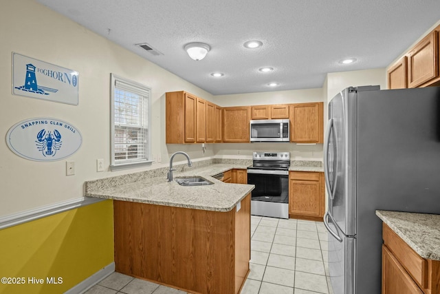 301 Derby Park Ave, New Bern, NC 28562 - kitchen with appliances with stainless steel finishes, a sink, a textured ceiling, a peninsula, and visible vents