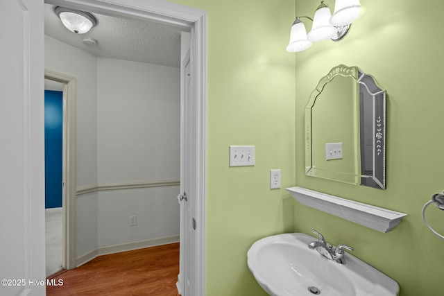 301 Derby Park Ave, New Bern, NC 28562 - bathroom featuring a textured ceiling, a sink, and wood finished floors