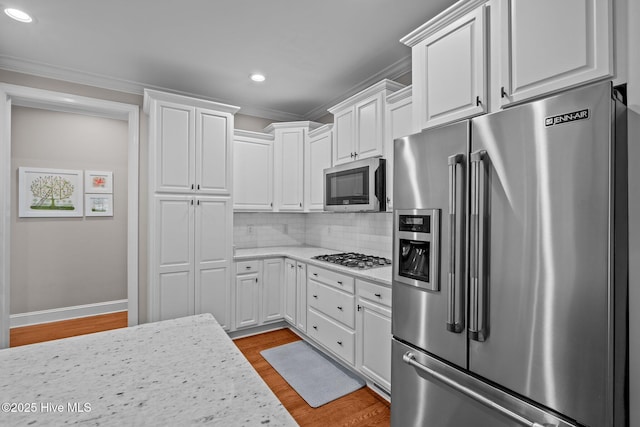 kitchen with recessed lighting, light wood finished floors, white cabinets, and stainless steel appliances
