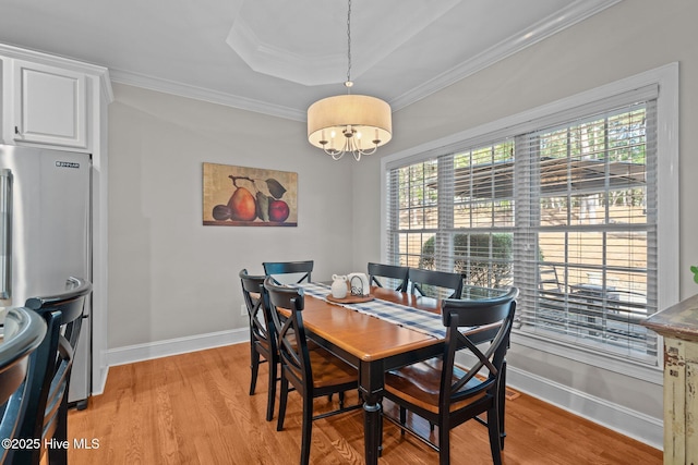 dining room with a healthy amount of sunlight, baseboards, and light wood finished floors