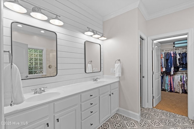 bathroom with a sink, baseboards, ornamental molding, and double vanity