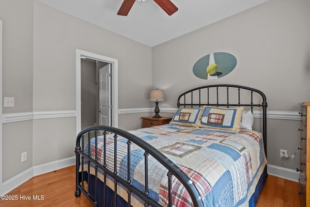 bedroom with baseboards, ceiling fan, and light wood-style flooring