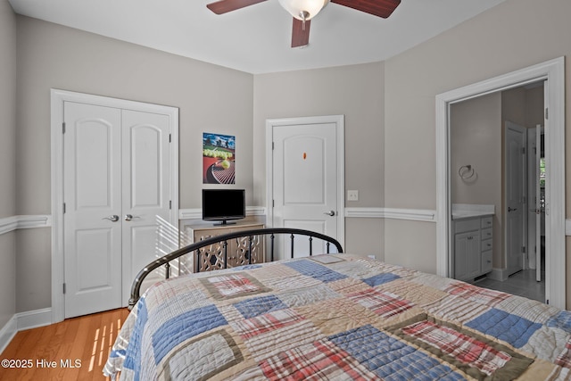 bedroom featuring a ceiling fan, light wood-style floors, baseboards, and a closet