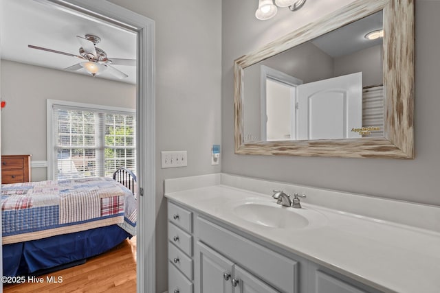 bathroom with a ceiling fan, wood finished floors, and vanity
