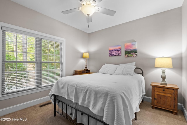 bedroom featuring baseboards, ceiling fan, visible vents, and light carpet