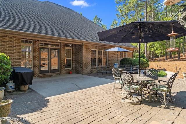 wooden deck featuring outdoor dining area, a patio area, and a grill