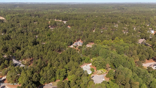 drone / aerial view with a wooded view