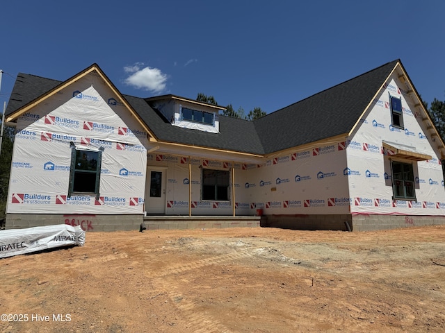 property in mid-construction with a shingled roof