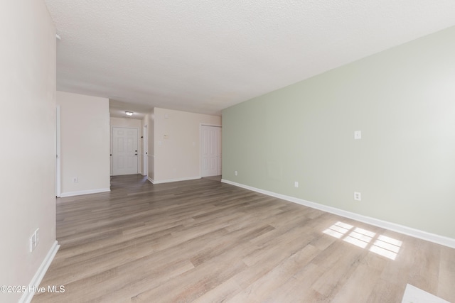 3002 E Windgate Ct, Jacksonville, NC 28546 - empty room featuring baseboards, light wood-style floors, and a textured ceiling