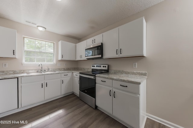 3002 E Windgate Ct, Jacksonville, NC 28546 - kitchen with a textured ceiling, light countertops, wood finished floors, appliances with stainless steel finishes, and a sink
