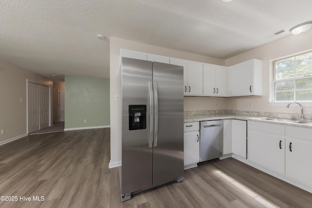 3002 E Windgate Ct, Jacksonville, NC 28546 - kitchen featuring light countertops, stainless steel appliances, a sink, visible vents, and white cabinets