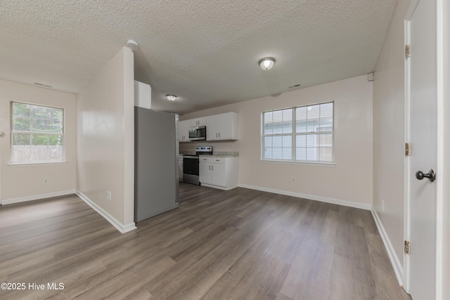 3002 E Windgate Ct, Jacksonville, NC 28546 - kitchen featuring open floor plan, stainless steel appliances, baseboards, white cabinets, and dark wood-type flooring