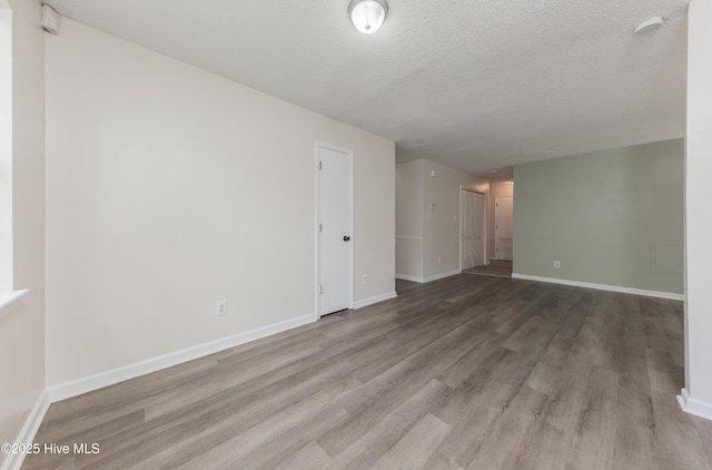 3002 E Windgate Ct, Jacksonville, NC 28546 - empty room featuring baseboards, a textured ceiling, and wood finished floors
