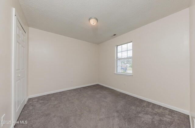 3002 E Windgate Ct, Jacksonville, NC 28546 - unfurnished bedroom featuring carpet, baseboards, a textured ceiling, visible vents, and a closet