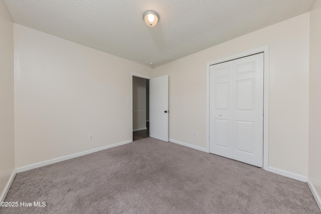3002 E Windgate Ct, Jacksonville, NC 28546 - unfurnished bedroom featuring carpet flooring, a closet, baseboards, and a textured ceiling