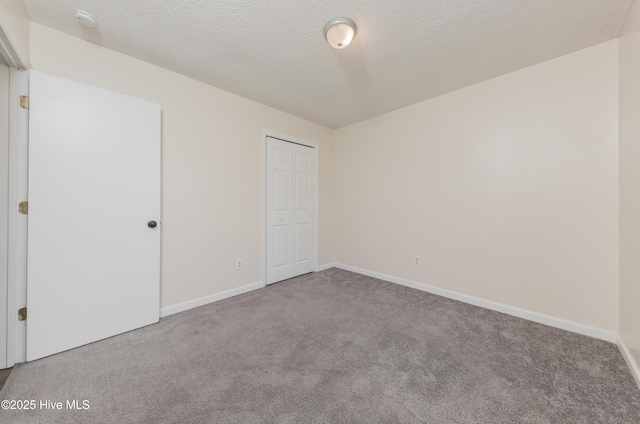 3002 E Windgate Ct, Jacksonville, NC 28546 - unfurnished bedroom with baseboards, carpet flooring, and a textured ceiling