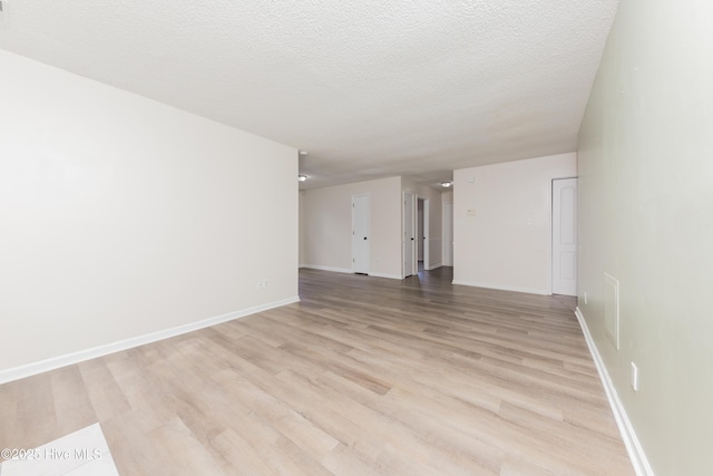 3002 E Windgate Ct, Jacksonville, NC 28546 - empty room featuring baseboards, a textured ceiling, and light wood-style floors