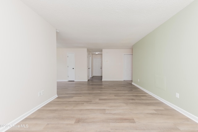 3002 E Windgate Ct, Jacksonville, NC 28546 - spare room featuring baseboards, a textured ceiling, and light wood-style floors