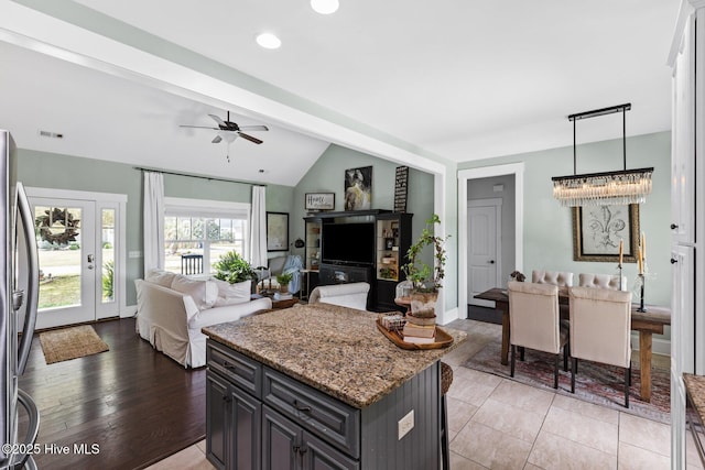 5994 Gray Squirrel Path, Southport, NC 28461 - kitchen featuring open floor plan, freestanding refrigerator, vaulted ceiling, light stone countertops, and ceiling fan