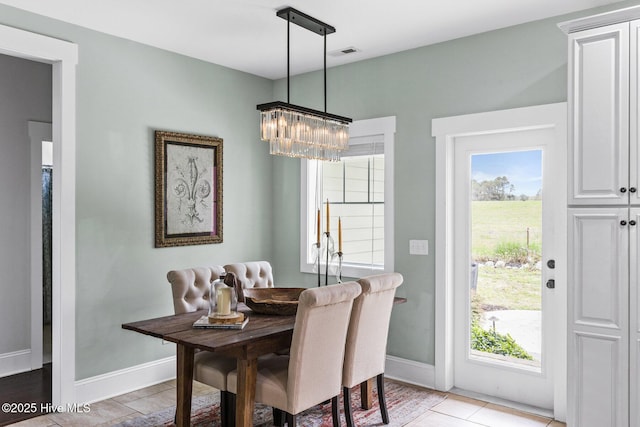 5994 Gray Squirrel Path, Southport, NC 28461 - dining space featuring a chandelier, healthy amount of natural light, baseboards, and light tile patterned floors