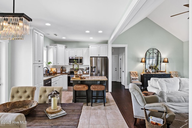 5994 Gray Squirrel Path, Southport, NC 28461 - kitchen with stainless steel appliances, open floor plan, a sink, a chandelier, and a kitchen bar