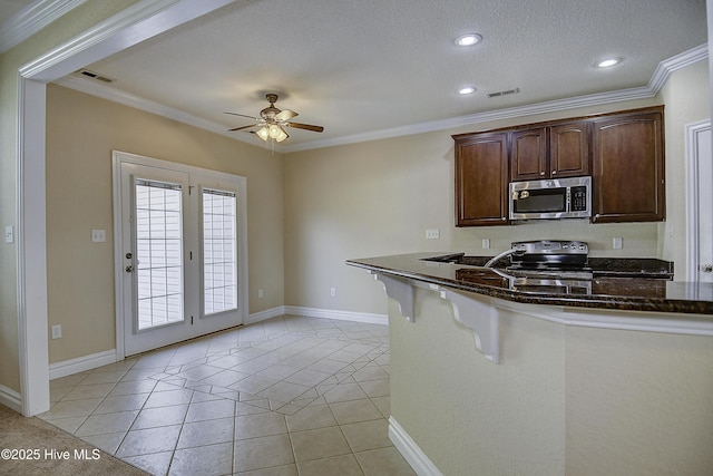 103 Whistling Duck Ct, Moyock, NC 27958 - kitchen with stainless steel microwave, black electric range oven, ceiling fan, crown molding, and light tile patterned floors