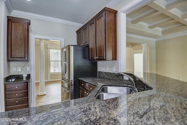 103 Whistling Duck Ct, Moyock, NC 27958 - kitchen featuring decorative columns, ornamental molding, a sink, light wood-style floors, and dark stone countertops