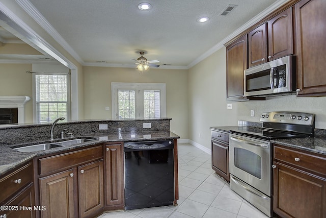 103 Whistling Duck Ct, Moyock, NC 27958 - kitchen featuring stainless steel appliances, a sink, ceiling fan, dark stone countertops, and light tile patterned flooring