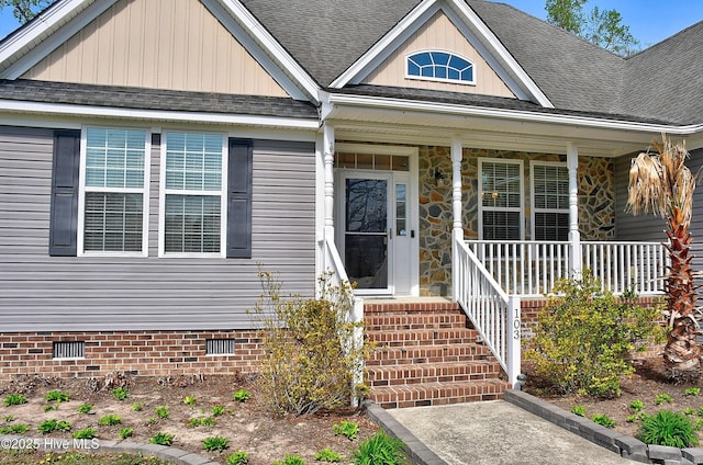 103 Whistling Duck Ct, Moyock, NC 27958 - view of exterior entry featuring crawl space, a shingled roof, a porch, and stone siding