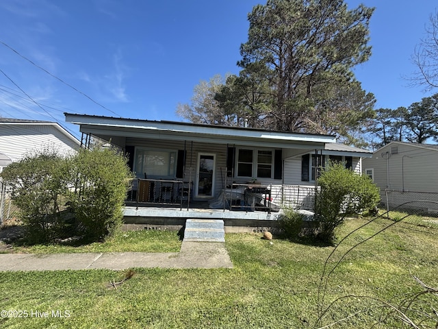 bungalow with a front yard, covered porch, and fence