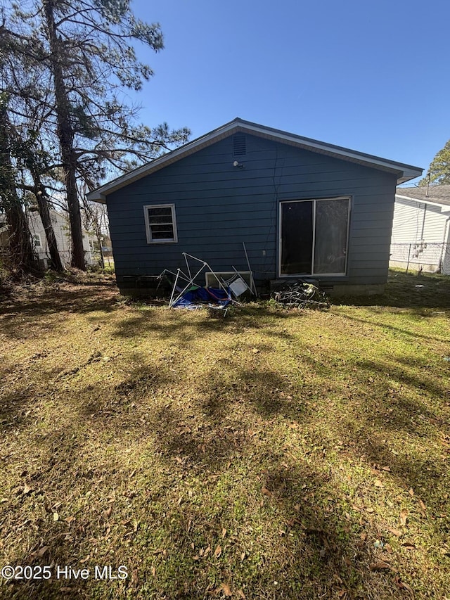 rear view of property featuring a yard