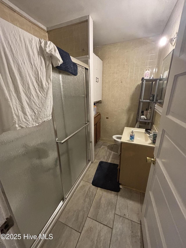 full bath with a stall shower, toilet, and vanity