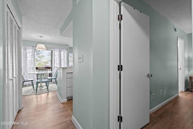 5 Pine Tree Rd Unit 211, Pinehurst, NC 28374 - corridor with a textured ceiling, light wood-type flooring, and baseboards