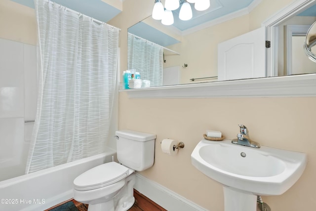 full bath with baseboards, a notable chandelier, a sink, toilet, and shower / bath combo with shower curtain