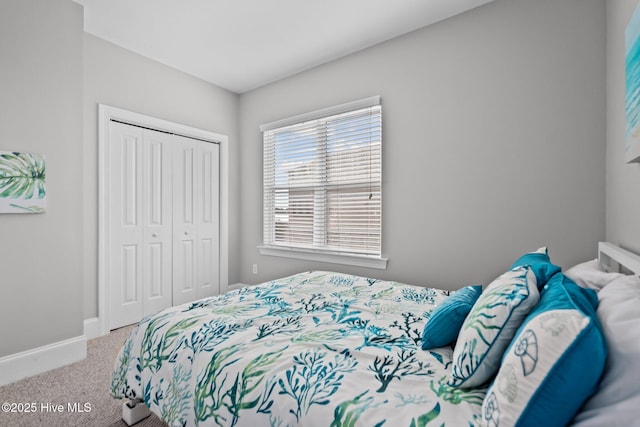 carpeted bedroom with baseboards and a closet