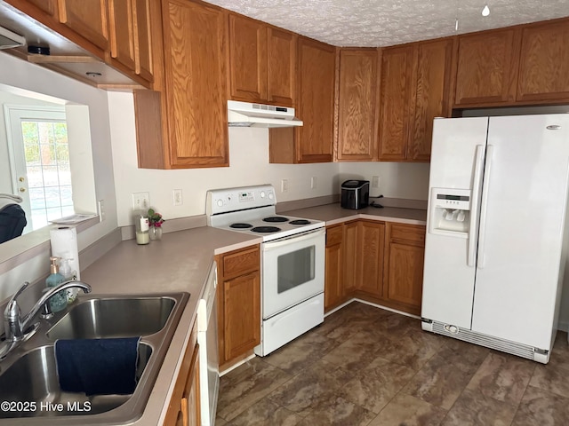 1735 W Pennsylvania Ave, Southern Pines, NC 28387 - kitchen featuring white appliances, under cabinet range hood, a sink, brown cabinets, and light countertops