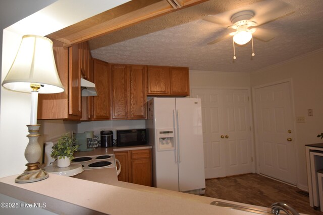 1735 W Pennsylvania Ave, Southern Pines, NC 28387 - kitchen with white fridge with ice dispenser, black microwave, brown cabinets, ceiling fan, and under cabinet range hood