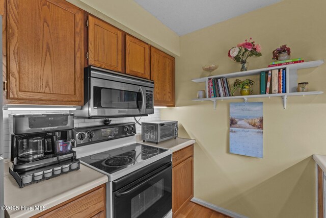 1 Vail Pl, Pinehurst, NC 28374 - kitchen with brown cabinets, light wood-type flooring, light countertops, a ceiling fan, and appliances with stainless steel finishes