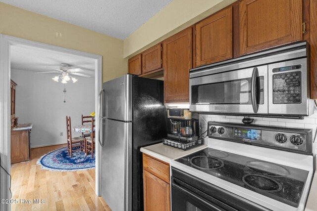 1 Vail Pl, Pinehurst, NC 28374 - kitchen featuring a ceiling fan, a sink, brown cabinets, light countertops, and light wood-type flooring