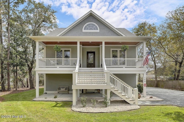 109 Drake Rd, Hampstead, NC 28443 - raised beach house with driveway, fence, a front lawn, and covered porch