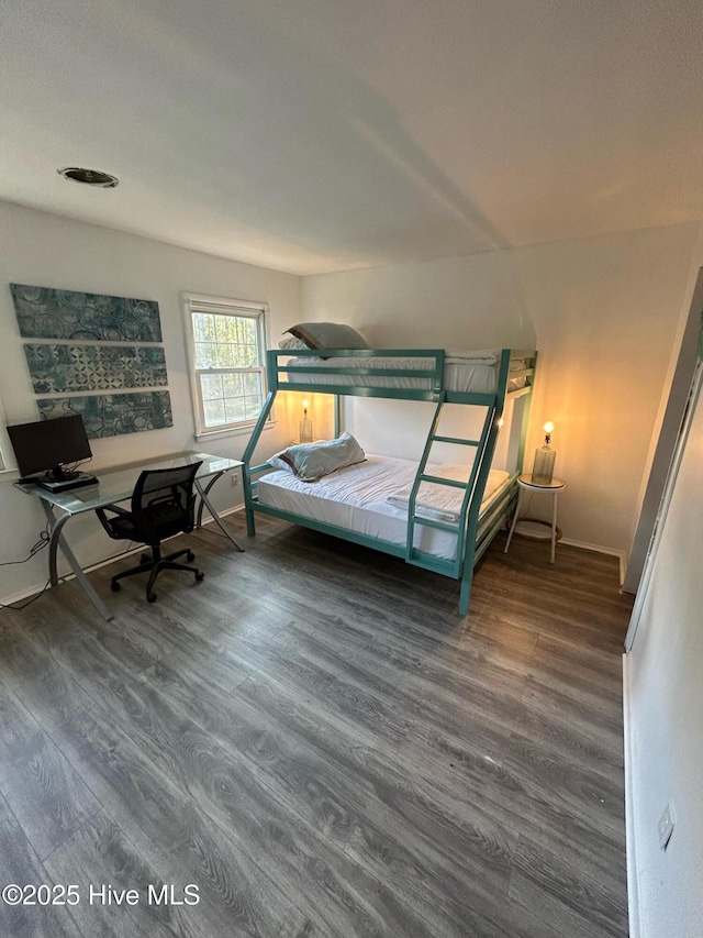 bedroom with baseboards and wood finished floors