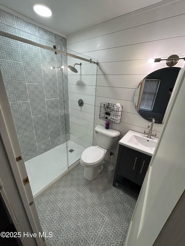 bathroom featuring vanity, a shower stall, and toilet