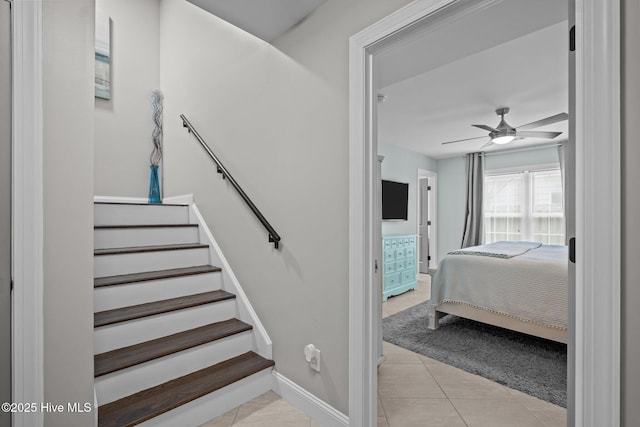 stairway with baseboards, tile patterned flooring, and ceiling fan