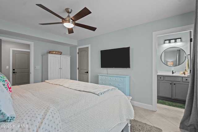 1317 Bowfin Ln Unit 2, Carolina Beach, NC 28428 - bedroom with light tile patterned floors, baseboards, a sink, ensuite bath, and ceiling fan