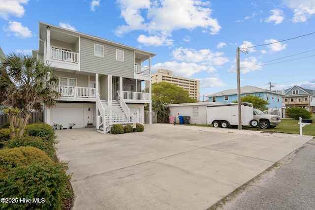 1317 Bowfin Ln Unit 2, Carolina Beach, NC 28428 - view of front of house with an attached garage, driveway, stairs, a balcony, and covered porch